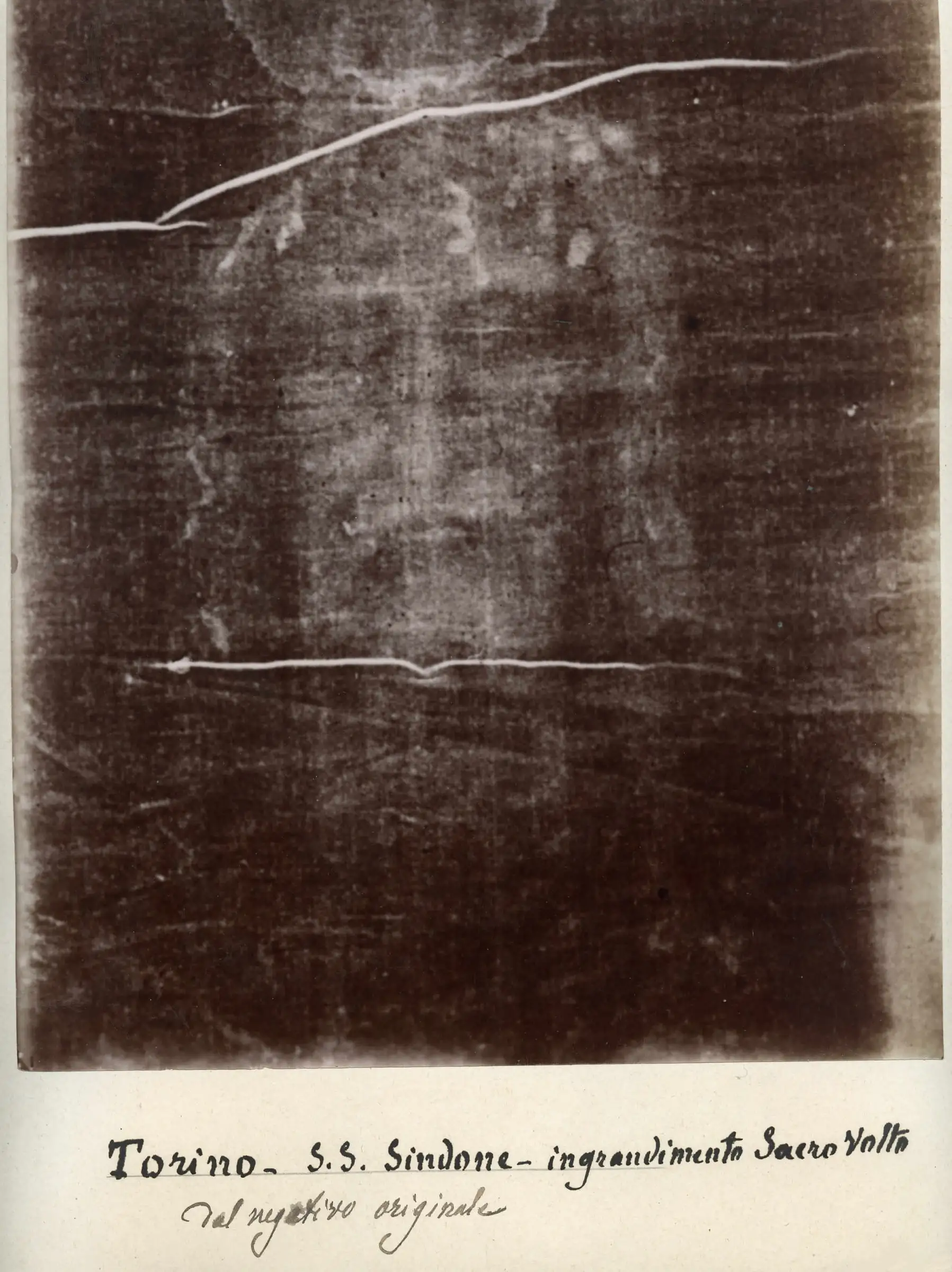 The face on the Shroud as it appears on Secondo Pia’s 1898 photographic negative: a bearded man with closed eyes, pale against dark.