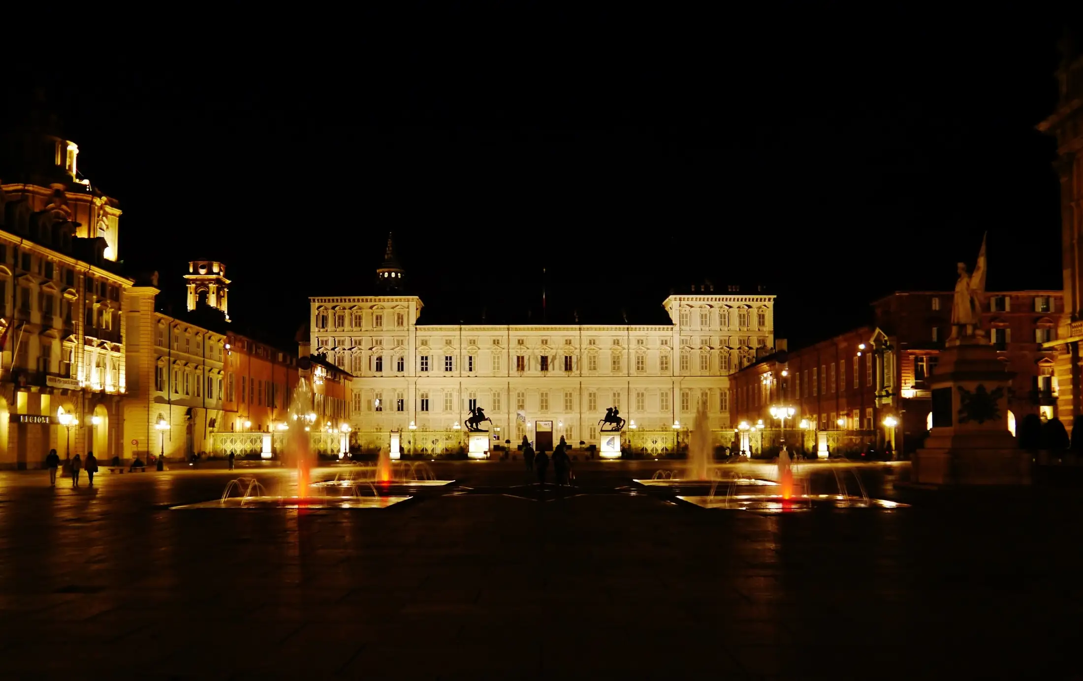 The front of the Royal Palace of Turin at night, lit from below, across the square.
